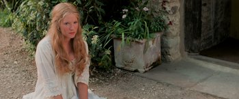 Movie still from “Stardust” (2007), directed by Matthew Vaughn – A young girl sitting on the ground in front of some flowers; Medium shot, High angle