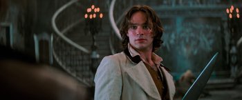 Movie still from “Stardust” (2007), directed by Matthew Vaughn – A man with long brown hair wearing a white jacket; Close Up shot, Low angle