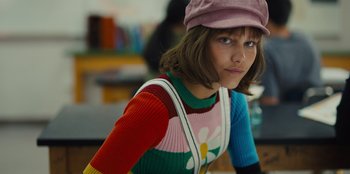 Movie still from “Stargirl” (2020), directed by Julia Hart – A young woman wearing a hat and a colorful sweater; Medium shot, High angle