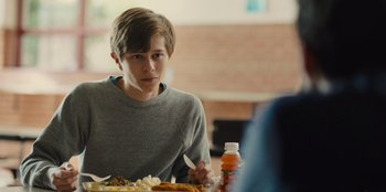 Movie still from “Stargirl” (2020), directed by Julia Hart – A man sitting at a table with food in front of him; Medium shot, Over the shoulder angle