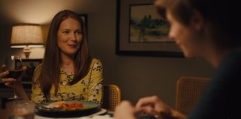 Movie still from “Stargirl” (2020), directed by Julia Hart – A woman sitting at a table with a plate of food; Medium shot, Over the shoulder angle