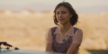 Movie still from “Stargirl” (2020), directed by Julia Hart – A young woman sitting in front of an open field; Close Up shot, Over the shoulder angle