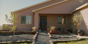 Movie still from “Stargirl” (2020), directed by Julia Hart – A man standing in front of a house with pots on the ground; Extreme Wide shot, Over the shoulder angle