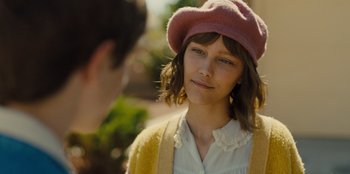 Movie still from “Stargirl” (2020), directed by Julia Hart – A young woman wearing a pink hat and a yellow jacket; Close Up shot, Over the shoulder angle