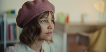 Movie still from “Stargirl” (2020), directed by Julia Hart – A young girl wearing a pink hat looking to her left; Close Up shot, Over the shoulder angle
