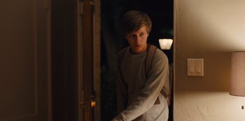 Movie still from “Stargirl” (2020), directed by Julia Hart – A young man standing in a doorway at night; Medium shot, Over the shoulder angle