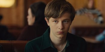 Movie still from “Stargirl” (2020), directed by Julia Hart – A young man in a green jacket looking at the camera; Close Up shot, Over the shoulder angle