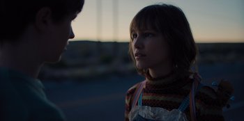 Movie still from “Stargirl” (2020), directed by Julia Hart – A woman standing next to another woman on a street; Close Up shot, Over the shoulder angle