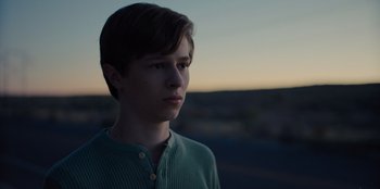 Movie still from “Stargirl” (2020), directed by Julia Hart – A young man is looking into the distance at dusk; Close Up shot, Low angle