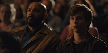 Movie still from “Stargirl” (2020), directed by Julia Hart – Two men are standing in a crowd of people; Close Up shot, Over the shoulder angle