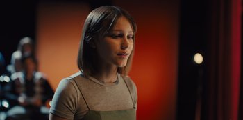 Movie still from “Stargirl” (2020), directed by Julia Hart – A young girl is standing in front of an orange background; Close Up shot, Low angle