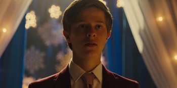 Movie still from “Stargirl” (2020), directed by Julia Hart – A man in a suit and tie in a dark room; Close Up shot, Over the shoulder angle