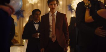 Movie still from “Stargirl” (2020), directed by Julia Hart – A man in a suit and tie standing next to another man in a suit and tie; Medium shot, Over the shoulder angle