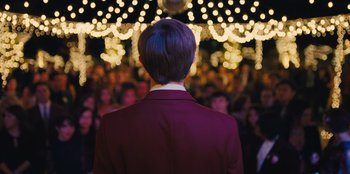 Movie still from “Stargirl” (2020), directed by Julia Hart – A man standing in front of a crowd of people at a concert; Medium shot, Over the shoulder angle