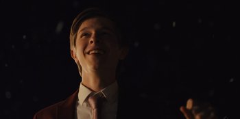 Movie still from “Stargirl” (2020), directed by Julia Hart – A young man wearing a suit and tie smiling; Close Up shot, Low angle