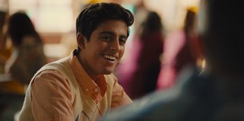 Movie still from “Stargirl” (2020), directed by Julia Hart – A young man smiles while sitting at a table; Close Up shot, Over the shoulder angle