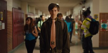 Movie still from “Stargirl” (2020), directed by Julia Hart – A young man wearing a pink tie in a school hallway; Medium shot, Low angle