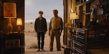 Movie still from “Stargirl” (2020), directed by Julia Hart – Two men standing next to each other on a dirt road; Wide shot, Over the shoulder angle