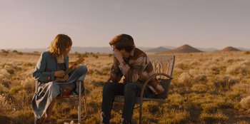 Movie still from “Stargirl” (2020), directed by Julia Hart – A man sitting on a chair next to a woman in a field; Wide shot, Over the shoulder angle