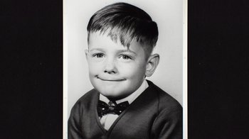 Movie still from “Still: A Michael J. Fox Movie” (2023), directed by Davis Guggenheim – An old black and white photo of a boy wearing a bow tie; Close Up shot, Overhead angle