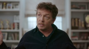 Movie still from “Still: A Michael J. Fox Movie” (2023), directed by Davis Guggenheim – A person wearing a black shirt; Close Up shot, Over the shoulder angle