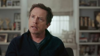 Movie still from “Still: A Michael J. Fox Movie” (2023), directed by Davis Guggenheim – A person sitting in a chair; Close Up shot, Over the shoulder angle