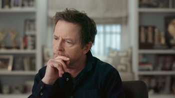 Movie still from “Still: A Michael J. Fox Movie” (2023), directed by Davis Guggenheim – A person sitting in a chair; Close Up shot, Over the shoulder angle