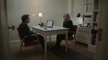 Movie still from “Still: A Michael J. Fox Movie” (2023), directed by Davis Guggenheim – A man and a woman sitting at a table with a computer; Wide shot, High angle