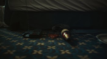 Movie still from “Still: A Michael J. Fox Movie” (2023), directed by Davis Guggenheim – A bottle of wine is laying on the ground; Extreme Close Up shot, Overhead angle