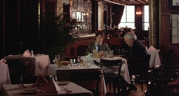 Movie still from “Still: A Michael J. Fox Movie” (2023), directed by Davis Guggenheim – Two people sitting at a table in a restaurant; Wide shot, Over the shoulder angle
