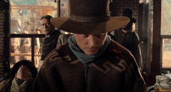 Movie still from “Still: A Michael J. Fox Movie” (2023), directed by Davis Guggenheim – A man wearing a brown hat and a brown poncho; Medium shot, Over the shoulder angle