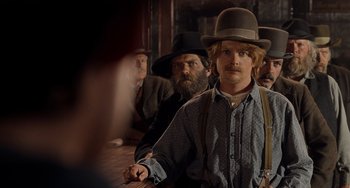 Movie still from “Still: A Michael J. Fox Movie” (2023), directed by Davis Guggenheim – A group of men in a room with hats on; Medium shot, Over the shoulder angle