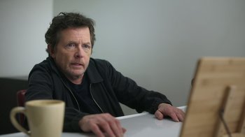 Movie still from “Still: A Michael J. Fox Movie” (2023), directed by Davis Guggenheim – A man sitting in front of a computer monitor; Close Up shot, Over the shoulder angle