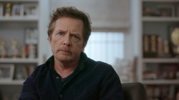 Movie still from “Still: A Michael J. Fox Movie” (2023), directed by Davis Guggenheim – A person sitting in a chair; Close Up shot, Over the shoulder angle
