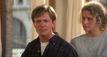 Movie still from “Still: A Michael J. Fox Movie” (2023), directed by Davis Guggenheim – A man in a plaid shirt standing next to another man; Close Up shot, Low angle