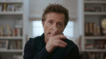 Movie still from “Still: A Michael J. Fox Movie” (2023), directed by Davis Guggenheim – A person sitting in a room; Close Up shot, Over the shoulder angle