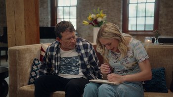 Movie still from “Still: A Michael J. Fox Movie” (2023), directed by Davis Guggenheim – A man and a woman sitting on a couch and writing; Medium shot, Over the shoulder angle
