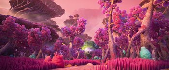 Movie still from “Strange World” (2022), directed by Don Hall – An animated scene of trees and bushes and a green creature; Extreme Wide shot, High angle