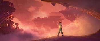 Movie still from “Strange World” (2022), directed by Don Hall – A man standing on top of a hill with his hands up; Extreme Wide shot, Overhead angle