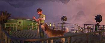 Movie still from “Strange World” (2022), directed by Don Hall – A man standing next to a brown and white dog on a dock; Wide shot, High angle