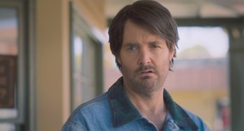 Movie still from “Strays” (2023), directed by Josh Greenbaum – A person wearing a jacket; Close Up shot, Over the shoulder angle