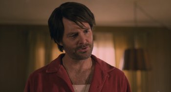 Movie still from “Strays” (2023), directed by Josh Greenbaum – A person wearing a red shirt; Close Up shot, Over the shoulder angle