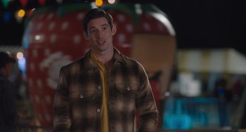 Movie still from “Strays” (2023), directed by Josh Greenbaum – A man wearing a plaid shirt and a yellow neck tie; Medium shot, Over the shoulder angle