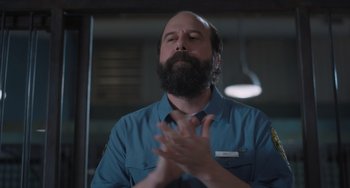 Movie still from “Strays” (2023), directed by Josh Greenbaum – A man with a goatee and beard clapping his hands; Close Up shot, Over the shoulder angle