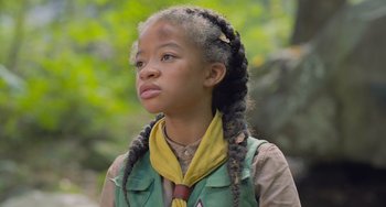 Movie still from “Strays” (2023), directed by Josh Greenbaum – A young girl with long braids looking upward; Close Up shot, Low angle