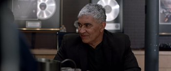 Movie still from “Studio 666” (2022), directed by BJ McDonnell – A person sitting at a table; Close Up shot, Over the shoulder angle