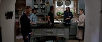 Movie still from “Studio 666” (2022), directed by BJ McDonnell – A group of people standing around a kitchen sink; Medium shot, High angle