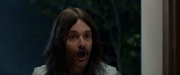 Movie still from “Studio 666” (2022), directed by BJ McDonnell – A person with long brown hair; Close Up shot, Over the shoulder angle