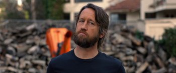 Movie still from “Studio 666” (2022), directed by BJ McDonnell – A man with long hair and a beard looking to his left; Close Up shot, Low angle