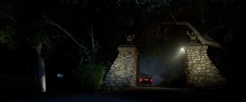 Movie still from “Studio 666” (2022), directed by BJ McDonnell – A car driving down a street at night near trees; Wide shot, Low angle